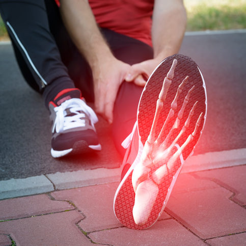 Foot Pain: Man runner outside with digital composite of foot bones